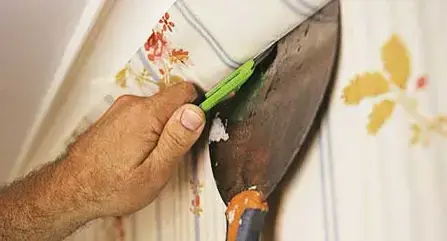 wallpaper being removed with scraping tools